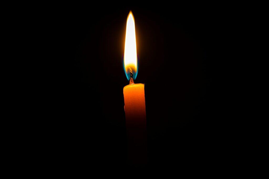 A single lit candle in a dark room