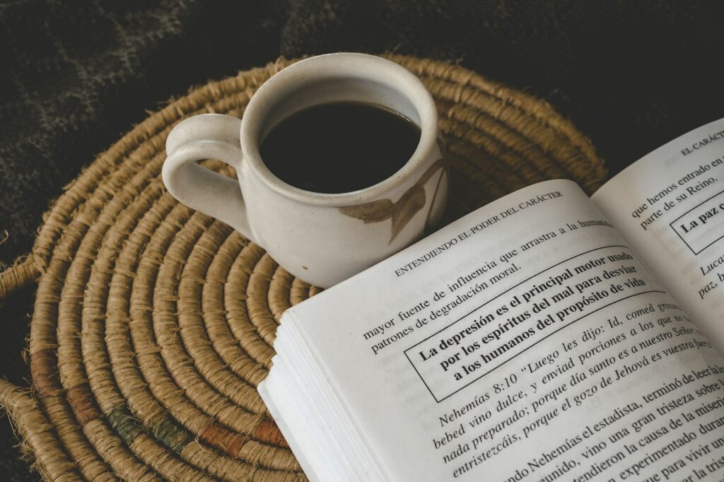 A cup of coffee beside an open book